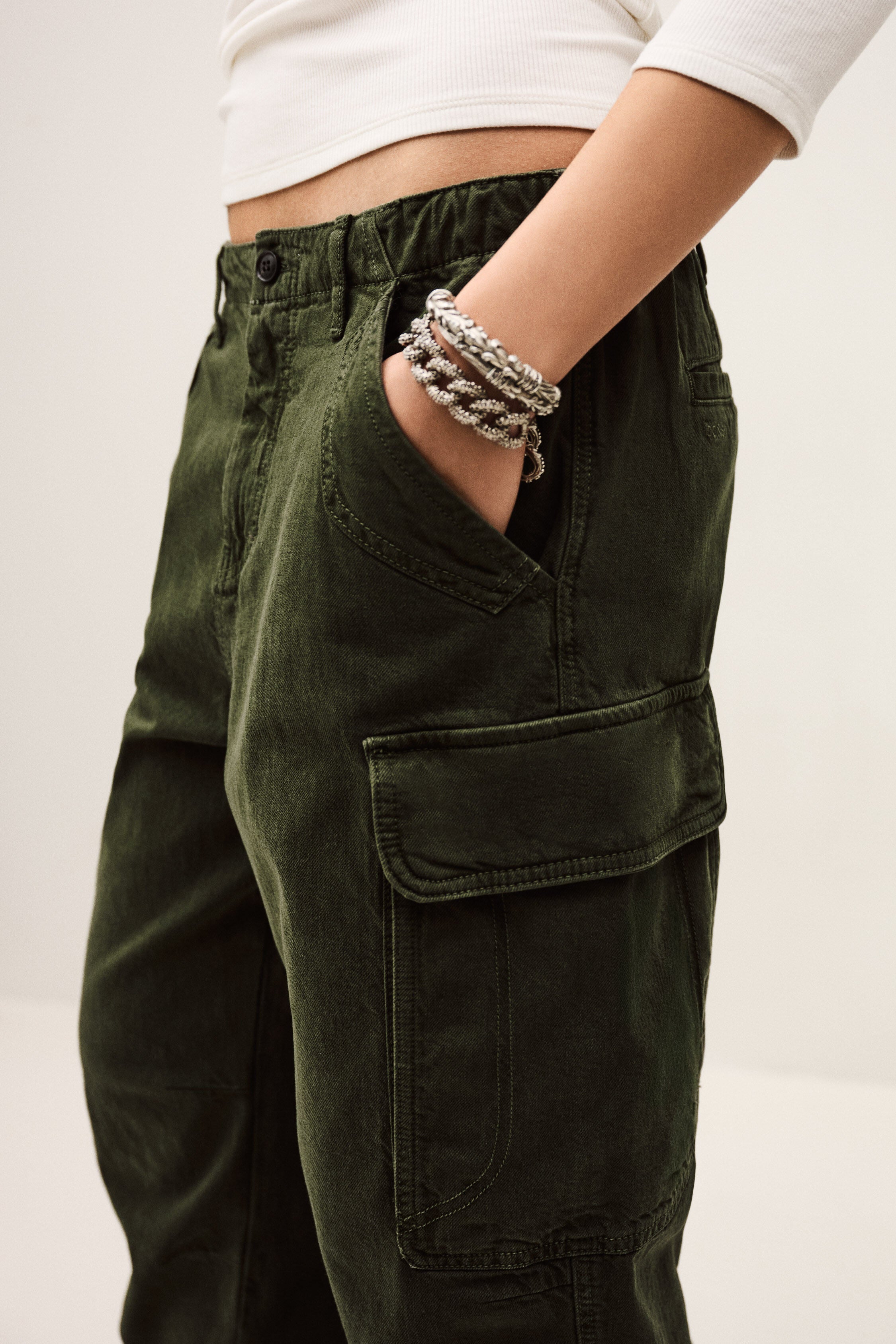 Person wearing green pants with a neutral background
